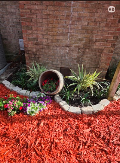Boardman Lawncare red mulch bed with stone edging and plantings