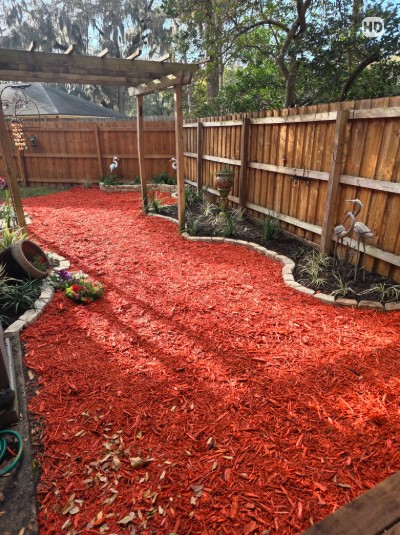 Boardman Lawncare red mulch bed with stone edging and plantings